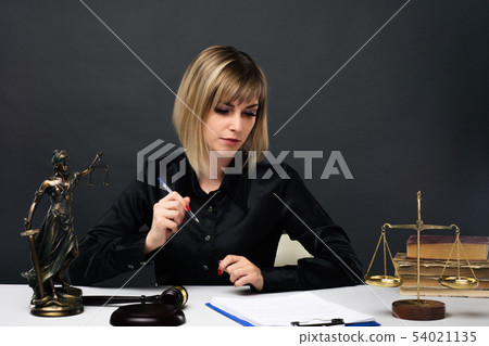 A young fair woman judge works in her office. 54021135