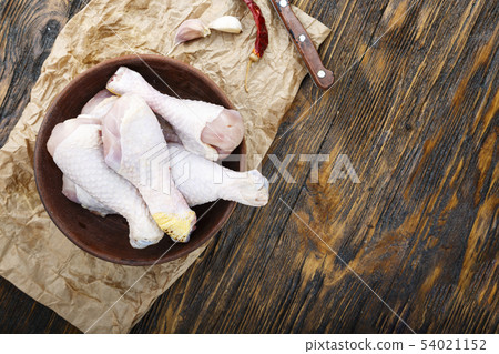 Raw uncooked chicken legs, drumsticks on wooden 54021152