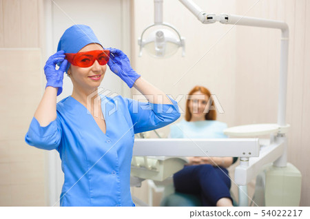 Dentist examining a patient's teeth in the dentist Dentist examining a patient's teeth in the dentist 54022217