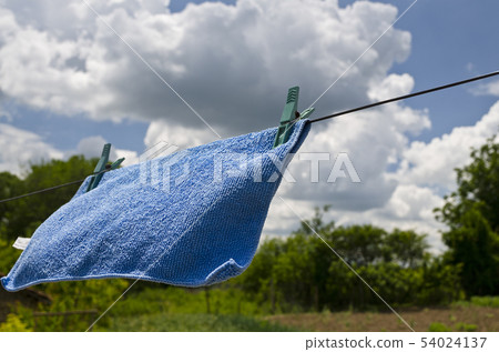 Clothes peg on a blue towel and washing line Clothes peg on a blue towel and washing line 54024137