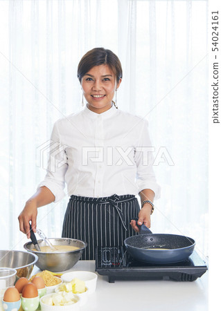 Young woman cook sweet cake in the kitchen Young woman cook sweet cake in the kitchen 54024161