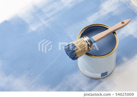 Brush and can of blue paint on blue background 54025009