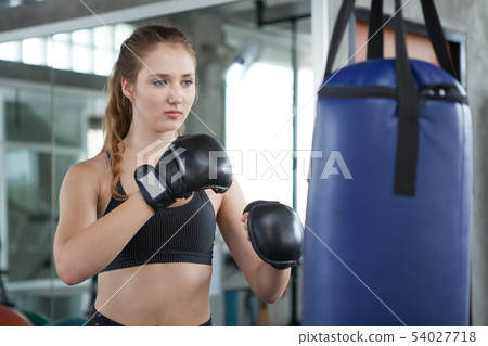 young fitness girl doing exercise hitting punching young fitness girl doing exercise hitting punching 54027718