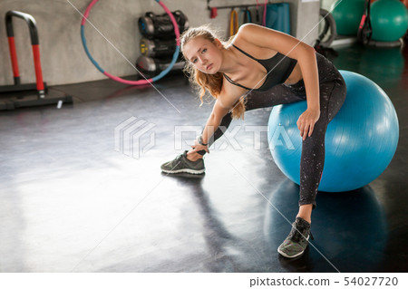 young fitness woman in sportswear stretching her 54027720