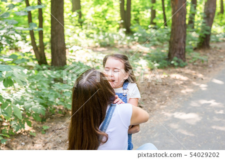 Family, nature, people concept - mother and daughter hugging in the park 54029202