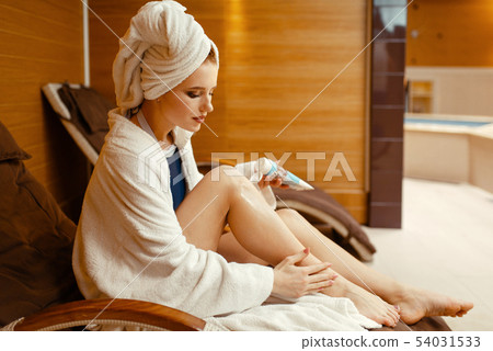 Sexy girl applying cream in spa chair, body care 54031533