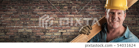 Male Contractor In Hard Hat Holding Wood Plank In Male Contractor In Hard Hat Holding Wood Plank In 54031624