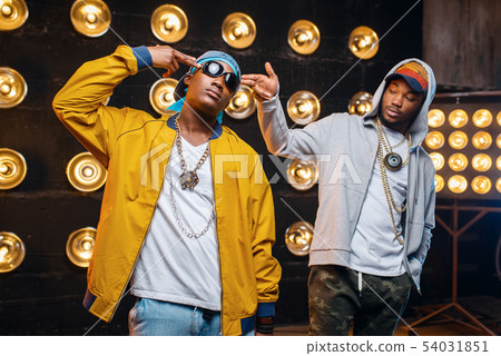 Two black rappers in caps, artists poses on stage Two black rappers in caps, artists poses on stage 54031851