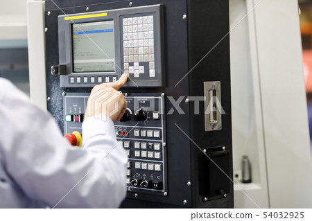 CNC machine operator working with a control panel 54032925