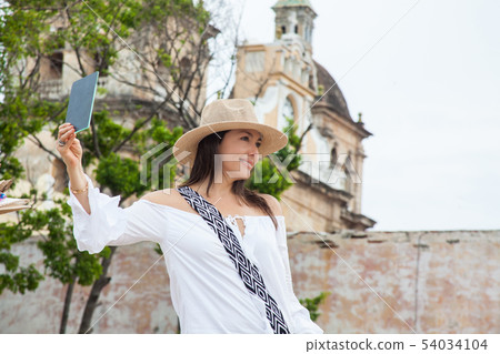 Woman trying on hats in Cartagena de Indias 54034104