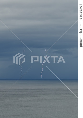 Photographing the scenery of the thunder that falls to the sea from the black clouds in early summer in Hokkaido, Atobe 54035891