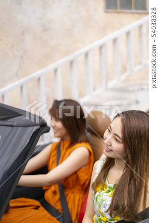 兩個漂亮的女人在一個女人的旅行中旅行,在時尚的微風中上升,帶著愉快的微風騎一輛敞篷車 兩個漂亮的女人在一個女人的旅行中旅行,在時尚的微風中上升,帶著愉快的微風騎一輛敞篷車 54038328