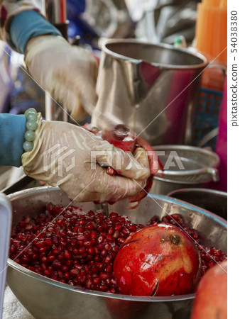 Vendor Extracts Pomegranate Seeds To Make Juice 54038380