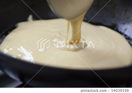 Baking a hot cake in a frying pan 54039198