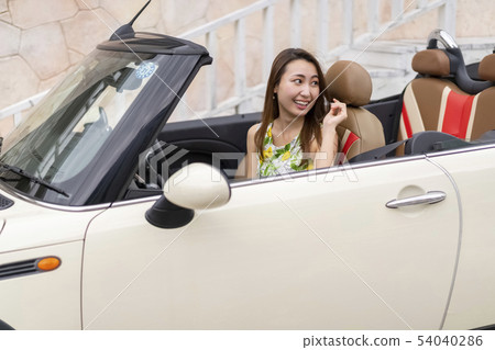 Cute beautiful woman who looks embarrassed to get on the passenger seat of boyfriend's open car for the first date Cute beautiful woman who looks embarrassed to get on the passenger seat of boyfriend's open car for the first date 54040286