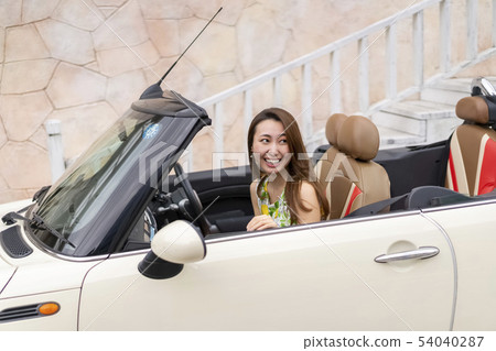 看起來很尷尬的逗人喜愛的美麗的婦女在男朋友的開放汽車的乘客座位為第一個日期 看起來很尷尬的逗人喜愛的美麗的婦女在男朋友的開放汽車的乘客座位為第一個日期 54040287