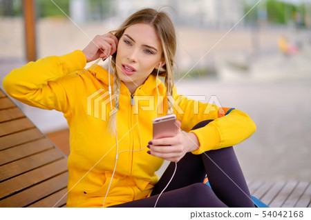 Woman listening music on her headphones Woman listening music on her headphones 54042168