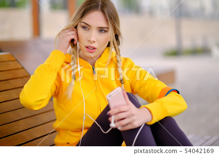 Woman listening music on her headphones Woman listening music on her headphones 54042169
