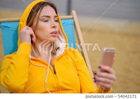 Woman listening music on her headphones 54042171
