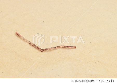 Plastic waste straw on sandy beach 54046513
