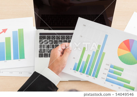 Men checking documents in front of a computer 54049546