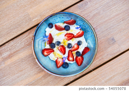 Healthy breakfast. Fresh fruit, Blueberry berries with yogurt. Morning Breakfast in a blue plate on 54055078