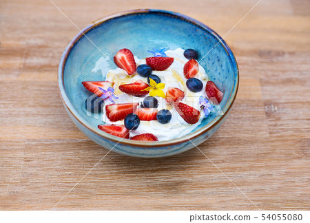 Healthy breakfast. Fresh fruit, Blueberry berries with yogurt. Morning Breakfast in a blue plate on 54055080