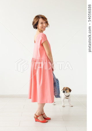 Cute young woman in a pink long dress posing with her beloved dog on a white background. Concept of Cute young woman in a pink long dress posing with her beloved dog on a white background. Concept of 54056886