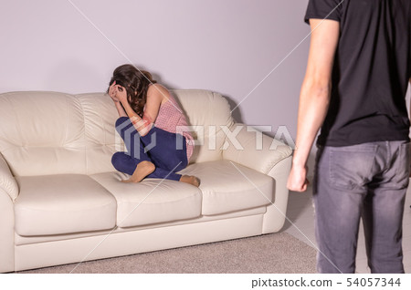 Domestic violence and abuse concept - man threatening with fist to crying woman Domestic violence and abuse concept - man threatening with fist to crying woman 54057344