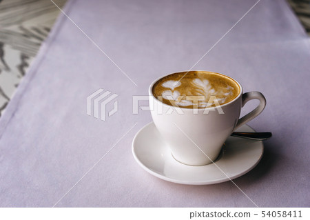 White mug on a saucer with cappuccino and beautiful heart-shaped milk foam White mug on a saucer with cappuccino and beautiful heart-shaped milk foam 54058411