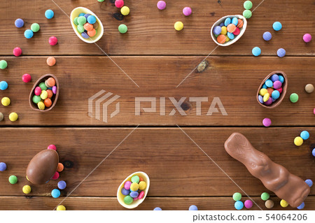 chocolate eggs, easter bunny and candies on wood 54064206