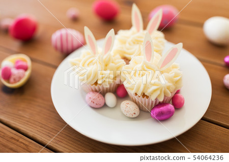cupcakes with easter eggs and candies on table cupcakes with easter eggs and candies on table 54064236