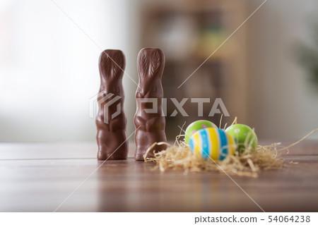 easter eggs in straw nest and chocolate bunnies easter eggs in straw nest and chocolate bunnies 54064238