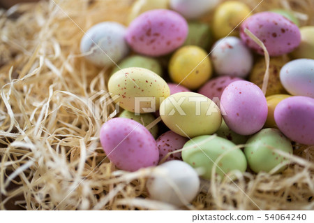 close up of easter egg candies in straw nest close up of easter egg candies in straw nest 54064240