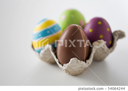 close up of chocolate and colored easter eggs close up of chocolate and colored easter eggs 54064244