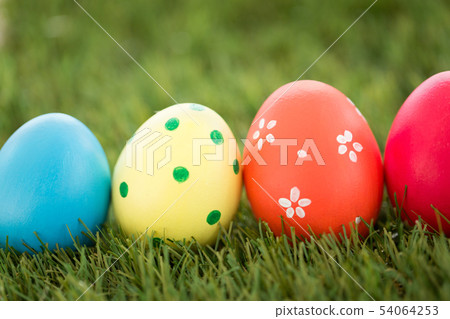 row of colored easter eggs on artificial grass row of colored easter eggs on artificial grass 54064253