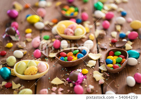 chocolate eggs and candy drops on wooden table chocolate eggs and candy drops on wooden table 54064259