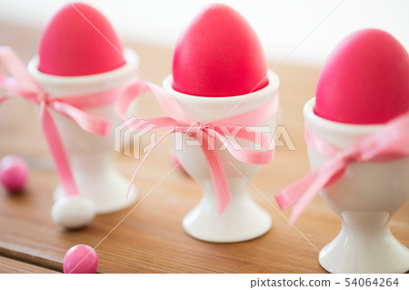 easter eggs in holders and candy drops on table easter eggs in holders and candy drops on table 54064264