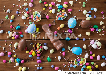 chocolate eggs, easter bunny and candies on wood 54064293