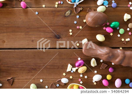 chocolate eggs, easter bunny and candies on wood 54064294