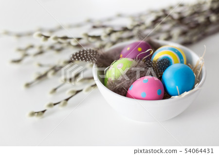 colored easter eggs and pussy willow branches 54064431