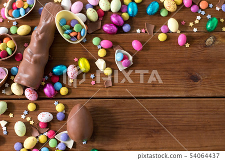 chocolate eggs, easter bunny and candies on wood 54064437