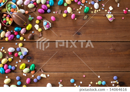 chocolate eggs and candy drops on wooden table chocolate eggs and candy drops on wooden table 54064616
