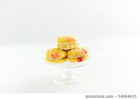 lemon yellow macarons on glass confectionery stand lemon yellow macarons on glass confectionery stand 54064635