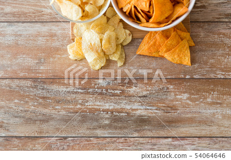 close up of potato crisps and nachos in bowls close up of potato crisps and nachos in bowls 54064646