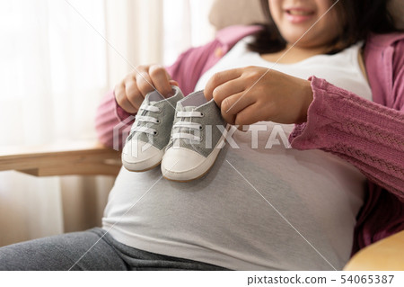 Happy pregnant woman and expecting baby at home. 54065387