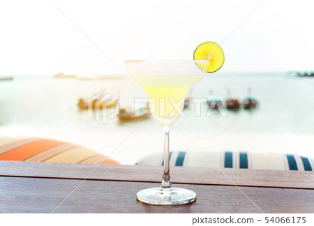 The frozen glass of Vodka cocktail on the beach The frozen glass of Vodka cocktail on the beach 54066175