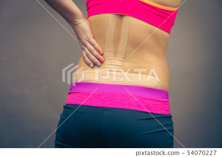 Woman with medical kinesio taping on back Woman with medical kinesio taping on back 54070227