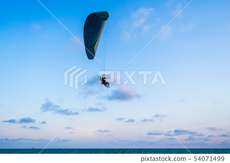 paraglider flying on sea and sky paraglider flying on sea and sky 54071499