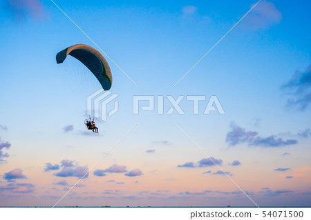paraglider flying on sky at sunset paraglider flying on sky at sunset 54071500